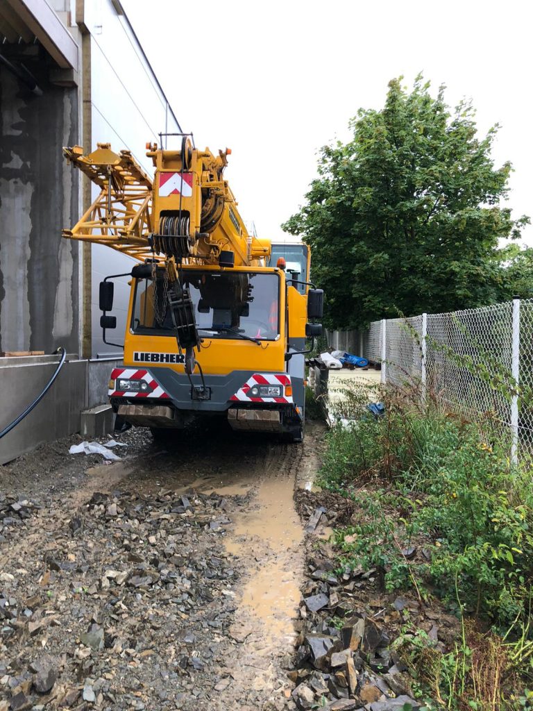 Autojeřáb Liebherr v náročném terénu u haly