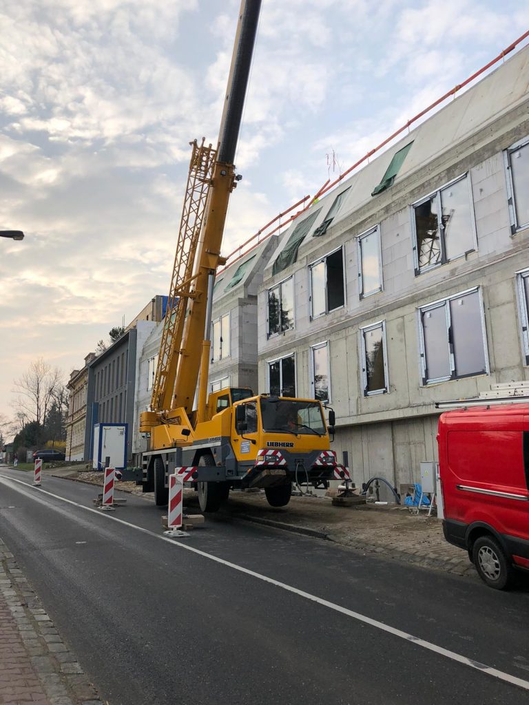 Autojeřáb Liebherr při práci u novostavby